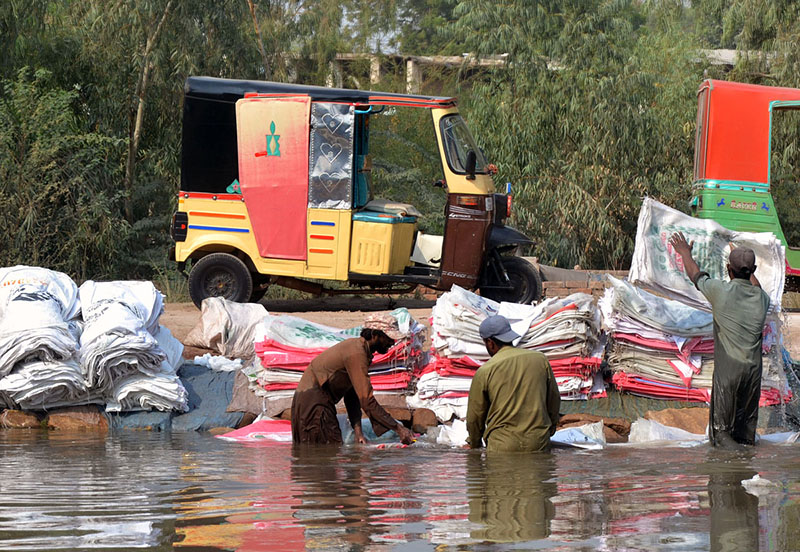 Laborers washing empty plastic bags in the canal