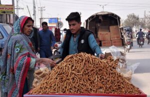 People busy in purchasing traditional sweet item jaggery from a vendor on roadside in the Federal Capital