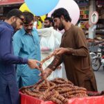 A vendor displaying and selling seasonal dry fruit figs (Anjeer) to attract the customers on his hand cart.