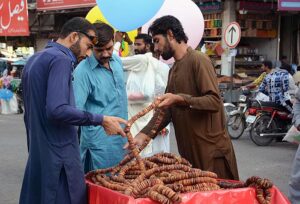 A vendor displaying and selling seasonal dry fruit figs (Anjeer) to attract the customers on his hand cart. 