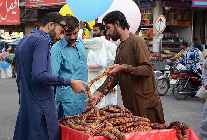A vendor displaying and selling seasonal dry fruit figs (Anjeer) to attract the customers on his hand cart.