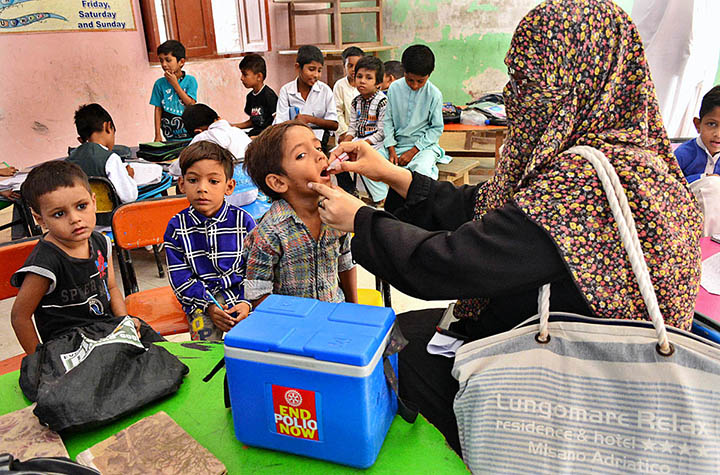 Health worker administering polio drops to a child during Anti-Polio Vaccination Campaign at Government Primary Boy’s School, Latifabad.