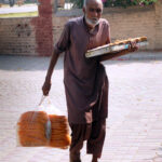 An elderly vendor selling edible items while shuttling in the park for livelihood