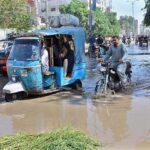 Vehicles passing through sewerage water accumulated on the road at Latifabad.