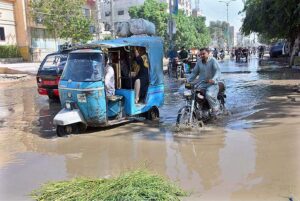 Vehicles passing through sewerage water accumulated on the road at Latifabad.
