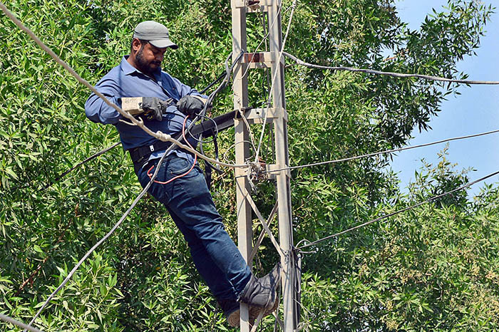 WAPDA staffer busy in cutting illegal line of electricity during crackdown against illegal connections.
