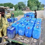 A person busy in filling their water cans with clean water from water pipeline at ISRA university road