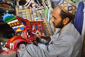 A painter busy in painting on model of truck at Dabgari area