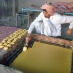 A worker busy in preparing traditional “Gurr” at Lahore Road