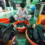 Labourer busy in washing imported second hand shoes before selling at Cantt Sasta Bazaar