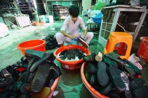  Labourer busy in washing imported second hand shoes before selling at Cantt Sasta Bazaar