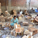 Workers busy in preparing wooden boxes at their workplace.