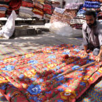 A man is sewing and manually making woven quilt at his work place for upcoming winter as the demand for woolies and quilts