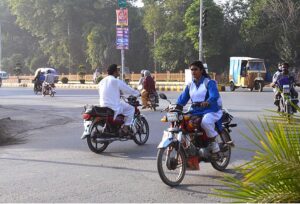 A female student riding motorcycle while going to school at Rehman Plaza Chowk.