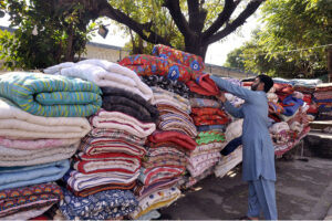 A man is sewing and manually making woven quilt at his work place for upcoming winter as the demand for woolies and quilts