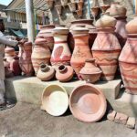 A vendor displaying clay made pots to attract the customers at Latifabad