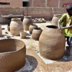 A worker busy in preparing the clay made pots at his workplace.