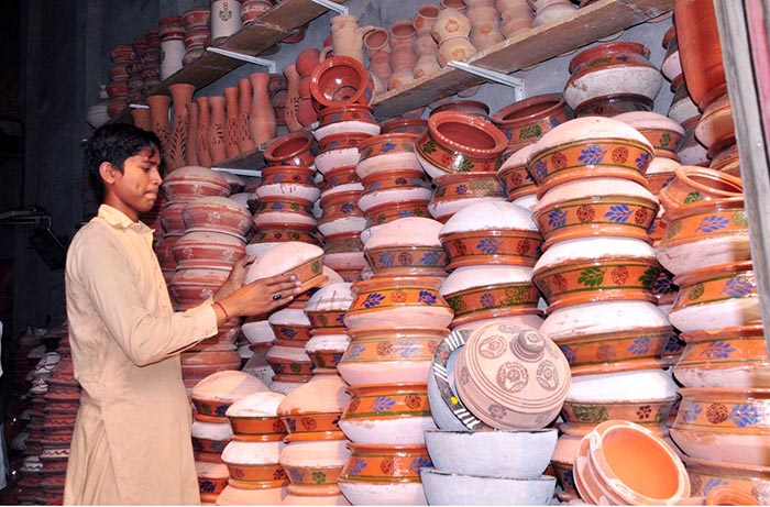 A vendor arranged clay made pots to attract customers at his shop.