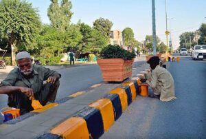 Labourers busy in paint the center path of road