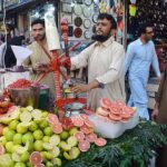 A vendor extracting pomegranate and grapefruit juices for customers at Qissa Khawani Bazaar