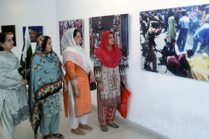 Visitors taking interest in photos during exhibition in connection with the Kashmir Solidarity Day at the Arts Council.