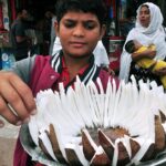 A young boy displaying and selling coconut at Gol chowk