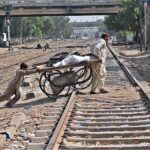 Hand cart holders crossing rail track near Cantt station