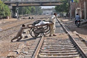 Hand cart holders crossing rail track near Cantt station