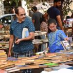 Customers are selecting old books from a roadside stall.