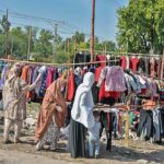 Women selecting and purchasing old clothes from setup along Islamabad Expressway