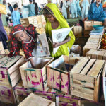 Young girls busy in preparing the wooden boxes for packing tomatoes at Vegetable Market.
