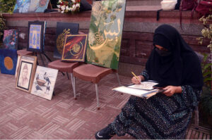 Student giving final touch to her painting during Painting and Calligraphy Exhibition organized by Formanite School System at Wazir Khan square inside Delhi gate