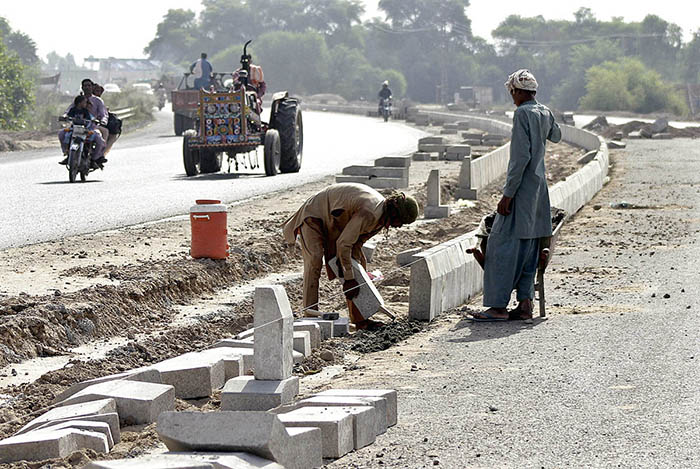 Labourers are busy in fixing the cemented block for the diversion of the newly constructed head Muhammad Wala road.