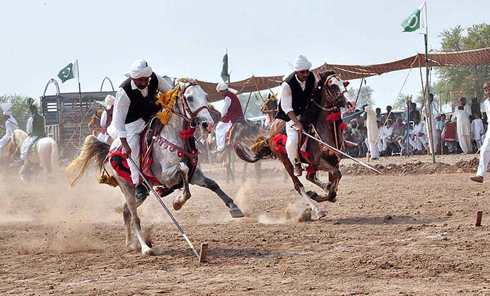 Horse riders participating in tent pegging during a tent pegging competition held at Mela Qureshia Chak no 163 NB