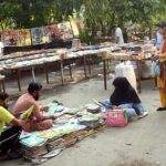 People busy in selecting and purchasing old books from a stall at Mall Road.