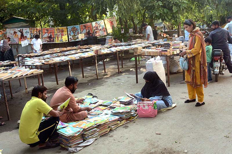 People busy in selecting and purchasing old books from a stall at Mall Road.