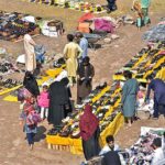 People busy in selecting and purchasing old shoes from vendors along Islamabad Expressway