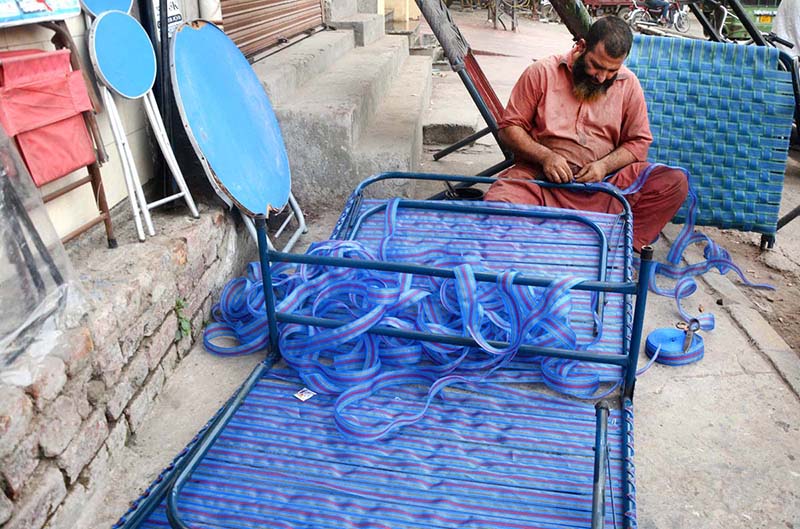 A man is busy knitting traditional bed (charpai) in his work place at lakshmi chowk