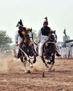 Horse rider participating in tent pegging during a tent pegging competition held at Mela Qureshia Chak no 163 NB.