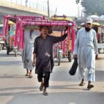 Street vendors displaying traditional beds (charpai) while shuttling on the road at Chowk Qazafi.