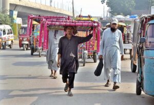 Street vendors displaying traditional beds (charpai) while shuttling on the road at Chowk Qazafi. 