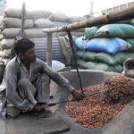 A vendor roasting peanuts at his setup.