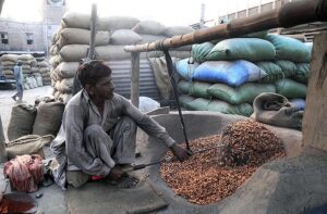A vendor roasting peanuts at his setup.