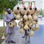 Vendor displaying bird nests on his bicycle to attract customers at Eidgah