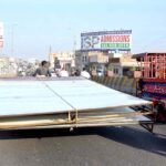 A tricycle rickshaw holder on the way loaded with Huge Billboards towards his destination creating a hurdle in the smooth flow of traffic needs the attention of concerned authorities