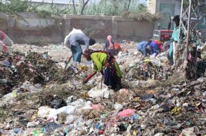 Gypsy people busy in searching valuables from the heap of garbage. 