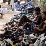Vendors waiting for costumers on his secondhand shoes stall at roadside in the Federal Capital.