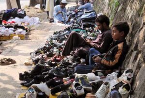 Vendors waiting for costumers on his secondhand shoes stall at roadside in the Federal Capital.