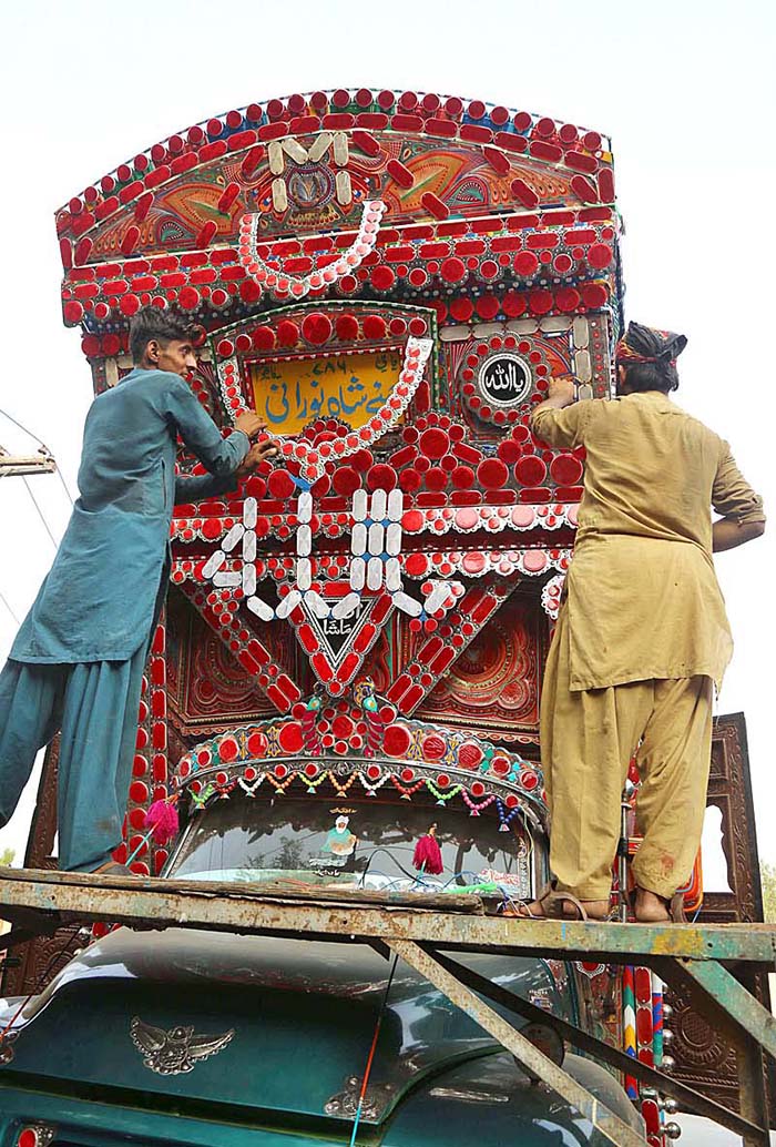 A worker busy in decorated truck body at Hala Naka Road.
