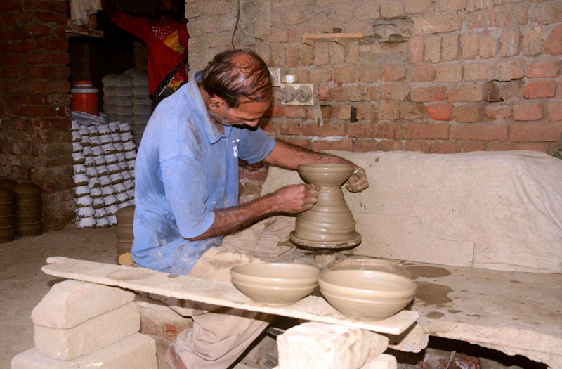 A craftsman preparing clay-made pots at his workplace